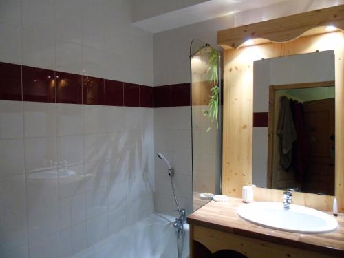 bagno con lavandino, vasca e specchio di ORELLE VALLEE DE LA MAURIENNE a Orelle
