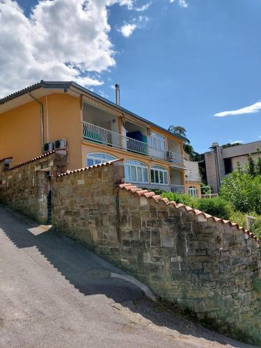 ein großes Haus hinter einer Steinmauer in der Unterkunft Apartma Tim Portorož in Portorož