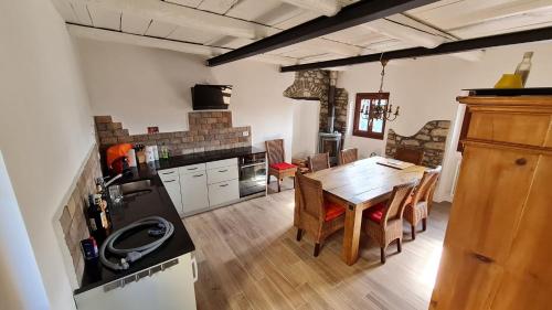 cocina y comedor con mesa de madera en Casa Diciotto, en Dolcedo