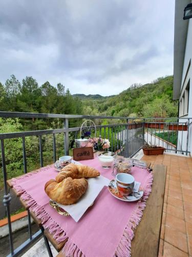 a table with bread and coffee on a balcony at Anthony House in Guardiabruna