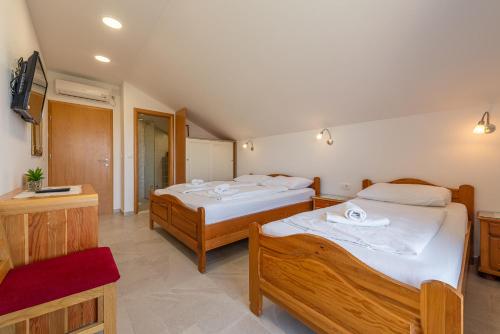 a bedroom with two beds and a bathroom at Bed & Breakfast Maki in Biograd na Moru