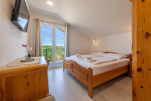 a bedroom with a bed and a large window at Bed & Breakfast Maki in Biograd na Moru