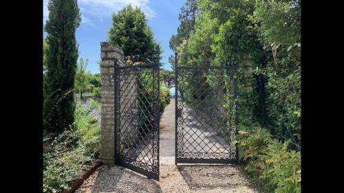 an open gate to a garden with a pathway at Luna27 in Toscolano Maderno