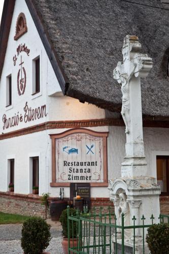 a building with a sign on the side of it at St.Michael Panzió Lovaspark in Vasszentmihály