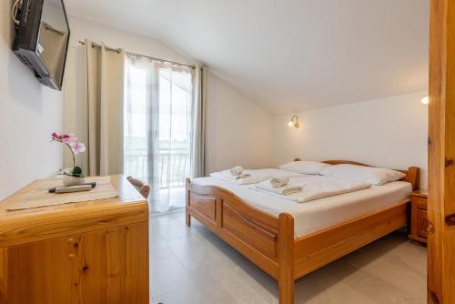 a bedroom with a bed and a large window at Bed & Breakfast Maki in Biograd na Moru