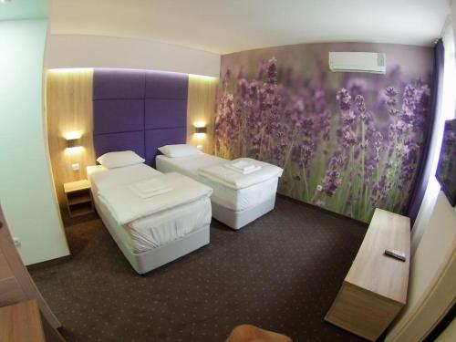 a hotel room with two beds and a purple wall at villa pergola in Trebinje