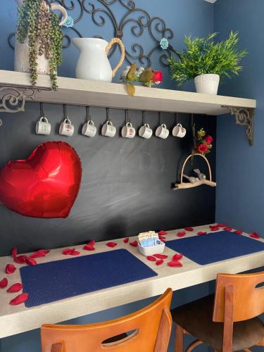 ein Schreibtisch mit einem roten Herz und ein Tisch mit Stühlen in der Unterkunft Aracaju Corais Hotel in Aracaju