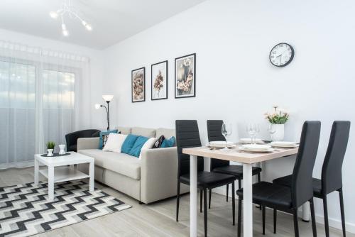 a living room with a table and a couch at Apartament SEA HOLIDAY in Kołobrzeg