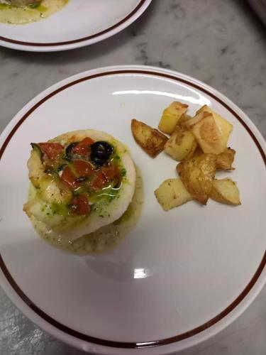 a plate of food with an egg and potatoes at Hotel Serafini Misano Adriatico in Misano Adriatico