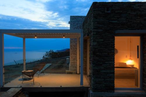 a room with a chair on a patio with a view at Iliades Luxury Boutique Suites in Batsi