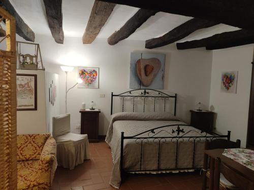 ein Schlafzimmer mit einem Bett und einem Stuhl in einem Zimmer in der Unterkunft La Tana del Grillo in Pitigliano