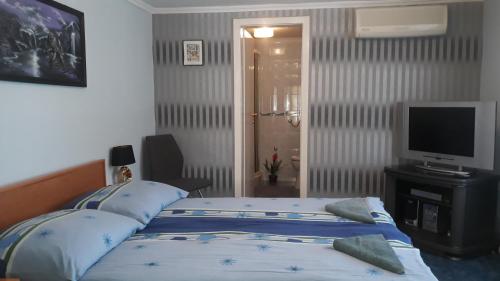 フォニョードにあるKirály Apartmanのベッドルーム(ベッド1台、薄型テレビ付)