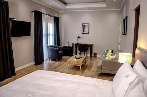 a bedroom with a bed and a living room at Terra Guest House in Maputo