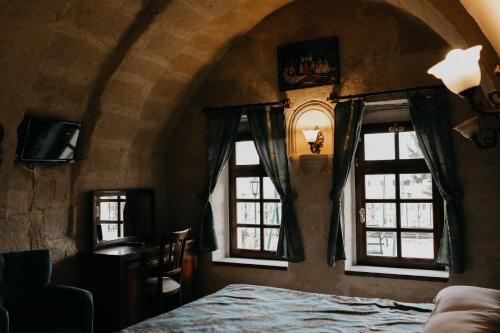 a bedroom with two windows and a bed in a room at Asteria Cave Hotel in Goreme
