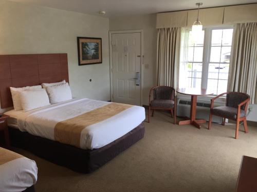 A bed or beds in a room at Quality Inn Lake George