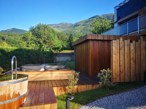 a garden with a hot tub and a fence at L'Argalyde Esprit Pyrénées Wellness & Cycling in Ayzac-Ost