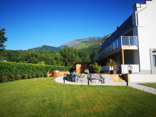 a building with a grassy yard in front of a building at L'Argalyde Esprit Pyrénées Wellness & Cycling in Ayzac-Ost