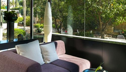 a purple couch in a room with a large window at Astari in Tarragona