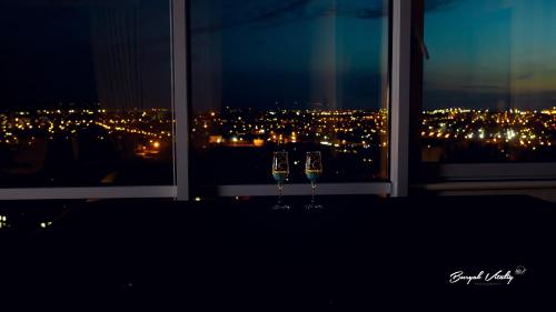 two wine glasses sitting on a window sill at night at Апартаменты в Одессе in Odesa
