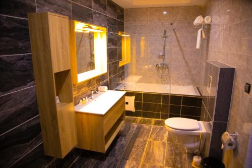 a bathroom with a sink and a tub and a toilet at Hotel La Casa Cielo in Cotonou