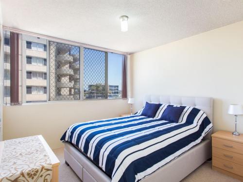 a bedroom with a bed and a large window at Ebbtide 6 in Forster