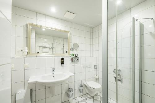 Berghotel Eisenach في إيزيناخ: حمام أبيض مع حوض ومرحاض