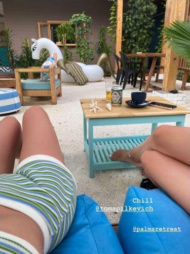 a person laying on the ground next to a table at Palms Retreat in Fulhadhoo