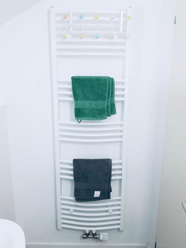 a towel rack with two green towels in a bathroom at Bleibe in Crailsheim