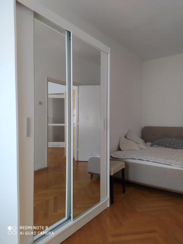 a sliding glass door in a bedroom with a bed at Dóm Tér Apartman in Szeged