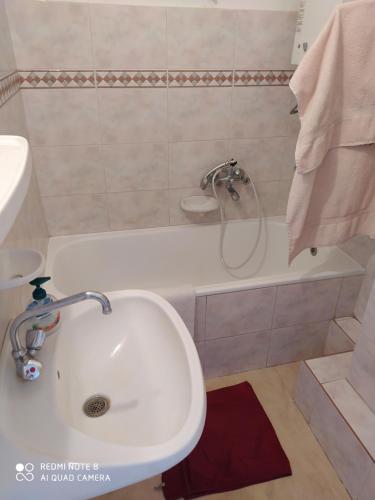 bagno con lavandino e vasca di Dóm Tér Apartman a Szeged