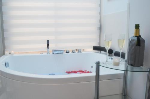 a bath tub with a bottle of wine and two wine glasses at Blue Horizon Luxury Apartment in Nerja