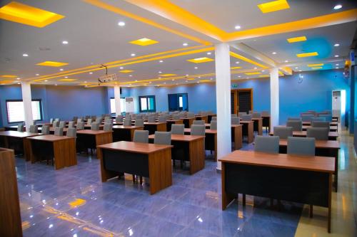 a large lecture room with tables and chairs at Hotel La Casa Cielo in Cotonou
