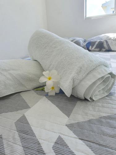 a white flower sitting on top of a bed at Solar das Rosas in Salvador