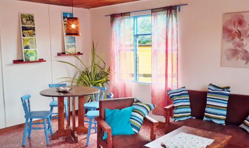 オロシにあるMontaña Linda Guest House Orosiのソファとテーブルと椅子のあるリビングルーム