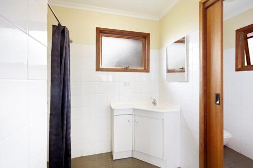 een badkamer met een wastafel en een spiegel bij Allestree Holiday Units in Portland