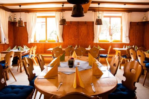 ein Esszimmer mit Tischen, Stühlen und Fenstern in der Unterkunft Zur frischen Quelle in Oberasbach