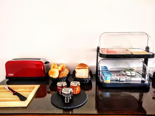 a table with bread and a toaster and some food at Residencial Douro in Peso da Régua