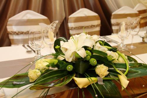 a bouquet of white flowers on a table at Csipke Hotel in Kiskunhalas