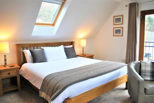 a bedroom with a bed and a window and a chair at Orchard House Bed and Breakfast in Portree