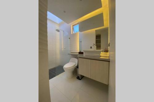 a white bathroom with a toilet and a sink at Luxury casa vacacional por días -mes bien dotada in Cali