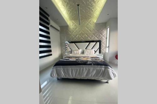 a bedroom with a bed with a black headboard at Luxury casa vacacional por días -mes bien dotada in Cali