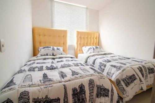 two beds sitting next to each other in a bedroom at apto vacacional in Cali