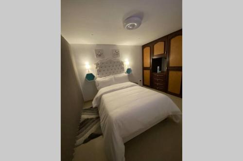 1 dormitorio con 1 cama grande con sábanas blancas en Hermoso apto 101 días semanas amoblado vacacionales, en Manizales