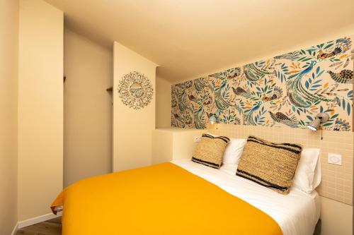 1 dormitorio con cama de color naranja y pared en Le Saint Victor Coeur de Cannes en Cannes