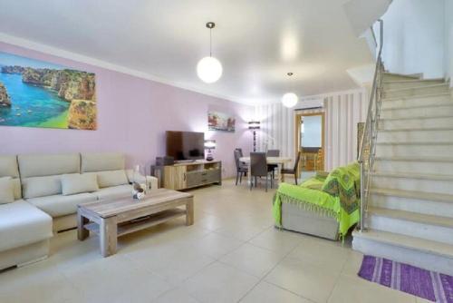 a living room with a couch and a table at MORADIA DO SOL in Olhão