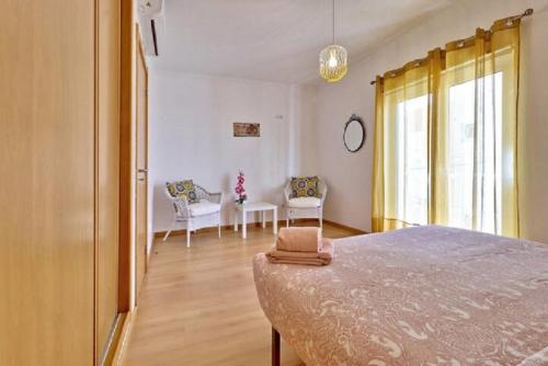 a bedroom with a bed and a table and chairs at MORADIA DO SOL in Olhão