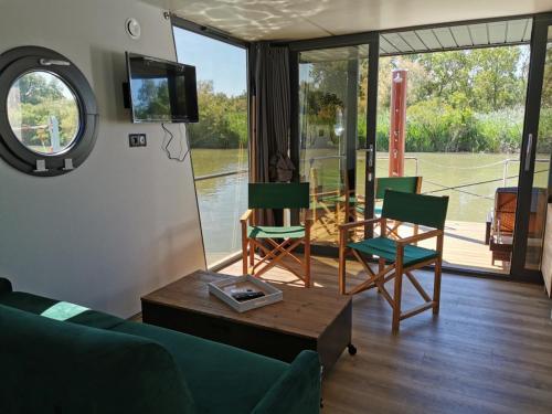 un salon avec un canapé, des chaises et une table dans l'établissement Rêves d'Ô en Camargue, clim réversible, parc naturel, à Vauvert