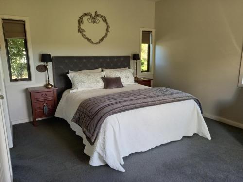 um quarto com uma cama grande e uma colcha branca em Appleyard em Kinloch