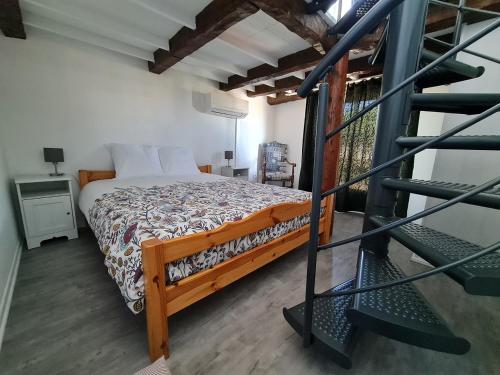 une chambre avec un lit et un escalier en colimaçon dans l'établissement Le 44 avec balcon vue mer, au Grau-du-Roi