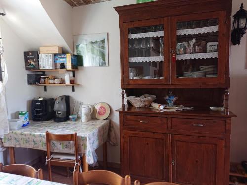 a kitchen with a large wooden cabinet and a table at La Quiete in Montenero di Bisaccia